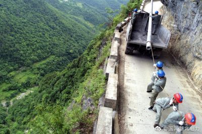 龍坪供電所用人力推車將8米長水泥電桿轉運到作業(yè)點